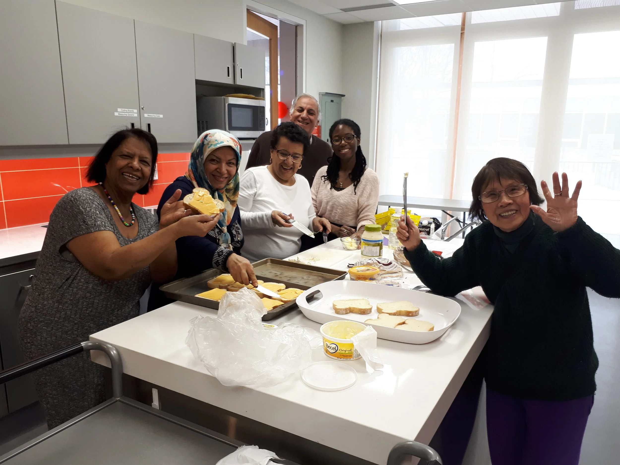 Group of participants smiling in the kitchen during a Cooking Program
