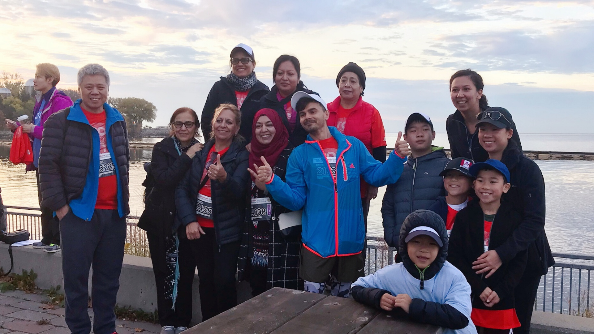 Group of adults and children by the lake.png