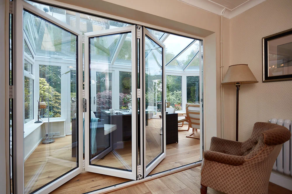 white bifold doors leading in to a upvc conservatory Matson4186.jpg
