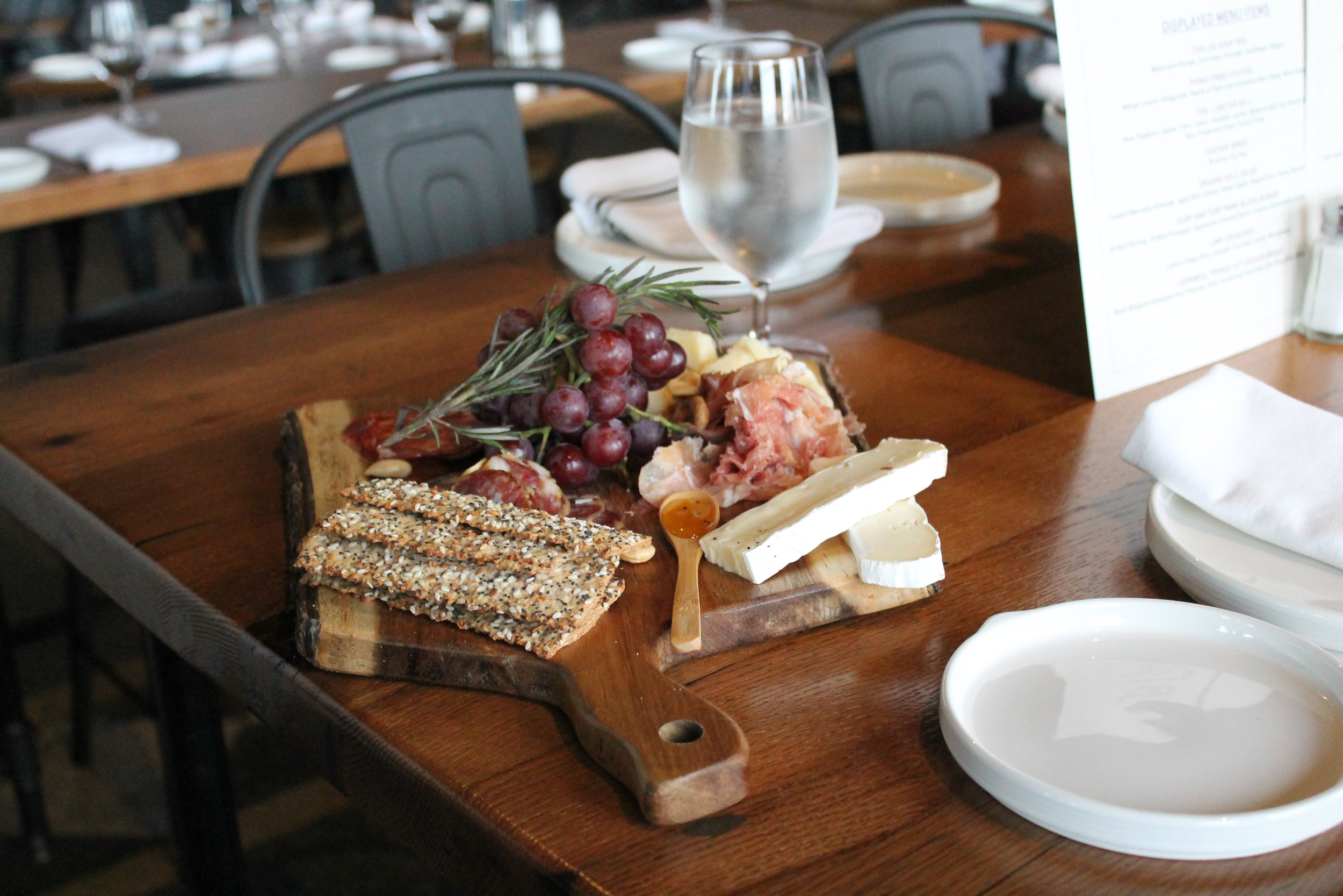 Charcuterie Board - Sliced Prosciutto de Parma, Alp's Sopressata, and Sweet Dried Sausage, French Brie, Aged Grana, Red Grapes, Truffle Honey, Crostini 