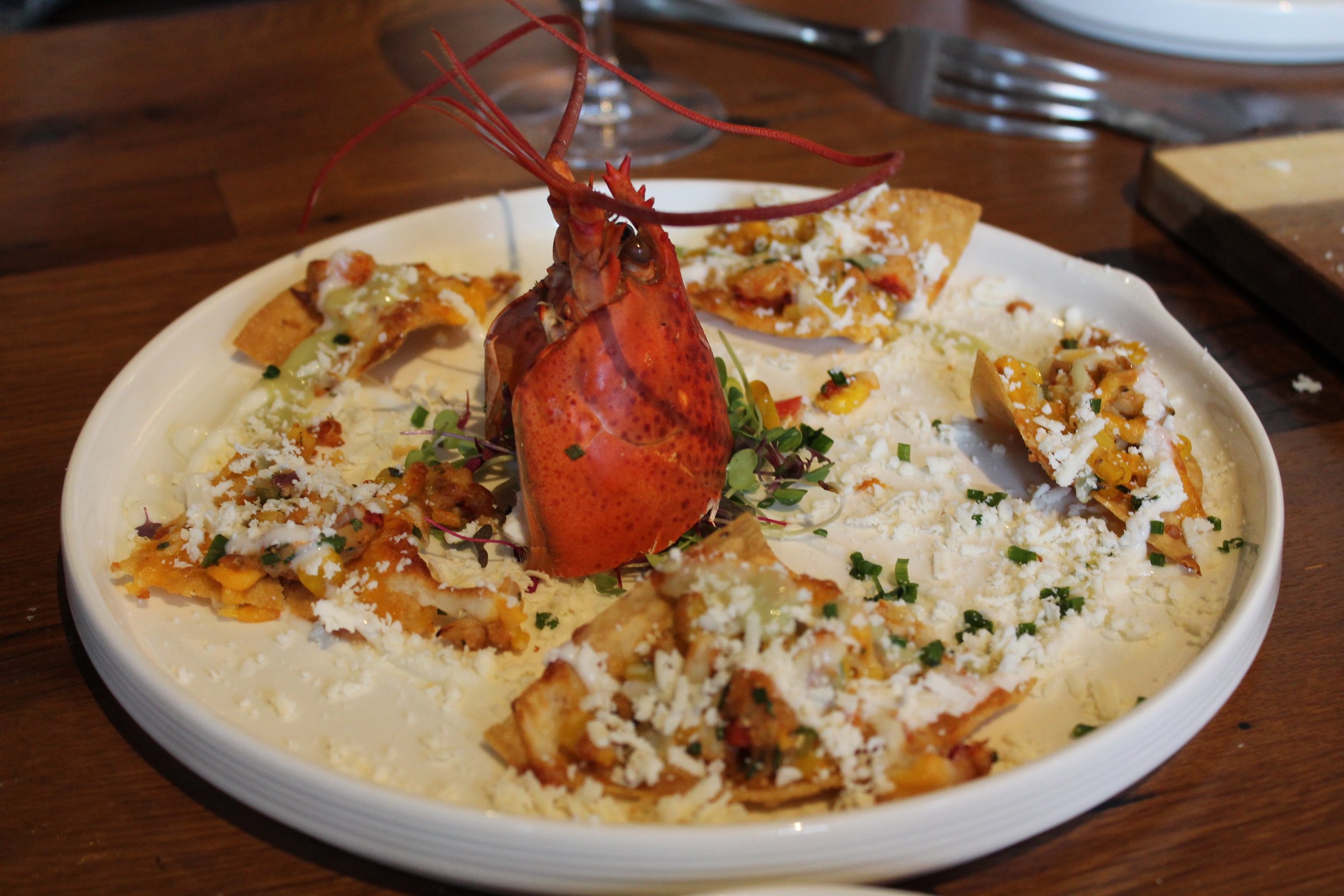 LOBSTER NACHOS - New England Lobster, Roasted Corn, Cilantro, Fresno Chili, Green Onion, Cotija, Lemon Cream, Avocado Cucumber Coulis
