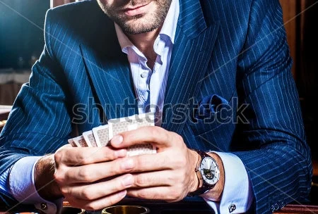 stock-photo--man-in-a-suit-player-sits-with-cards-in-a-hand-145026466.jpg