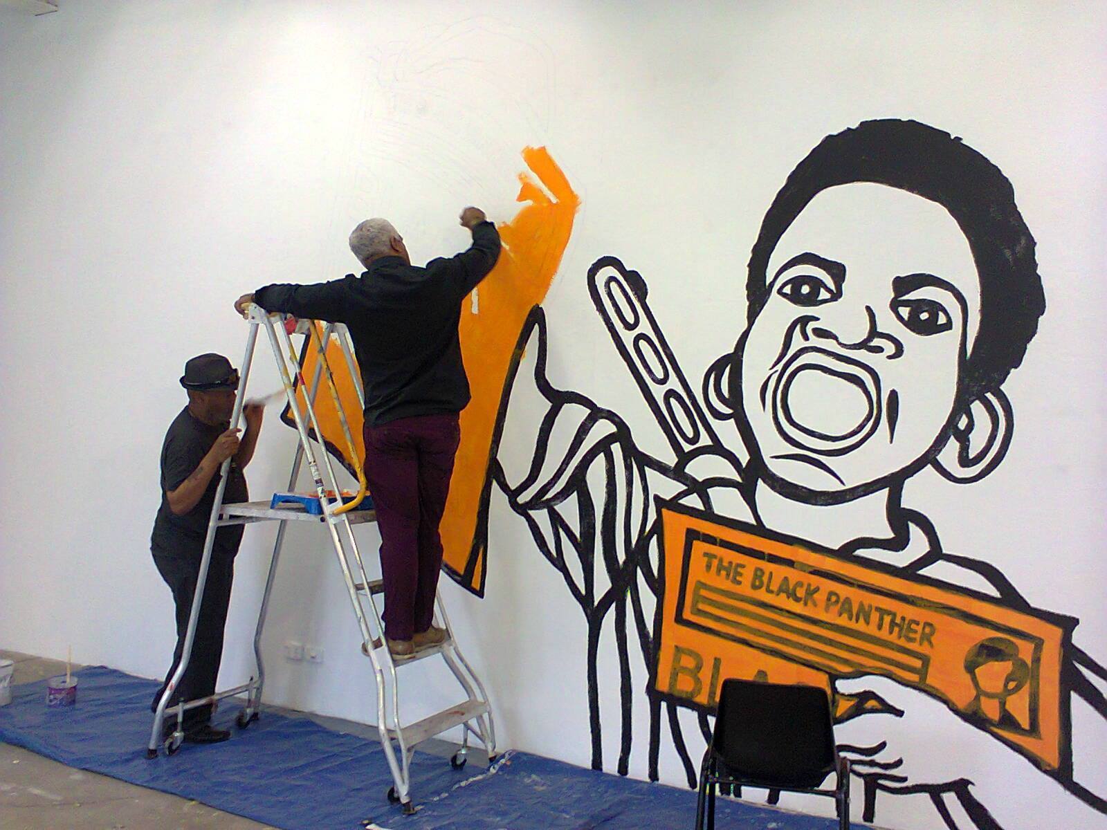 Emory Douglas installing/painting a poster recreation (2015)