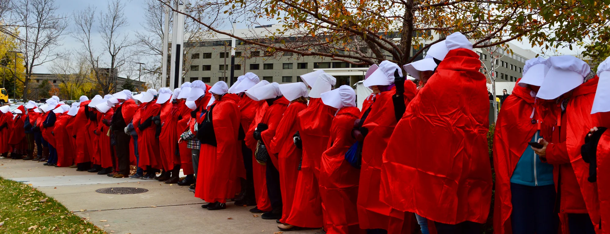 Protesters in Denver dressed as handmaids greet Mike Pence.