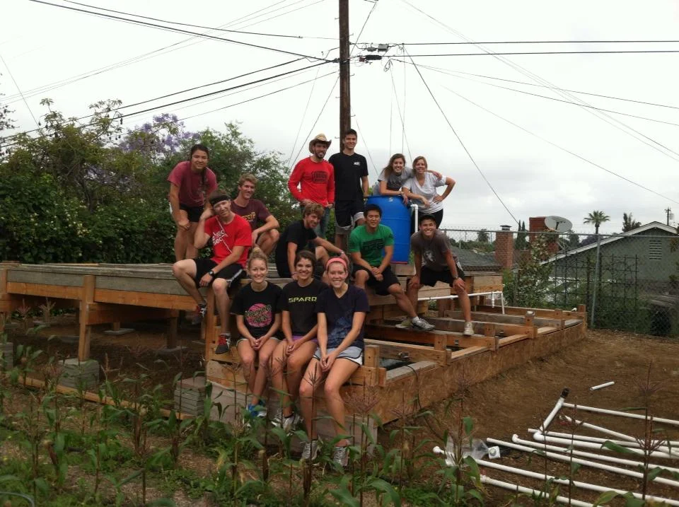 A group of volunteers help construct an aquaponic farm at a University in Los Angeles, CA.
