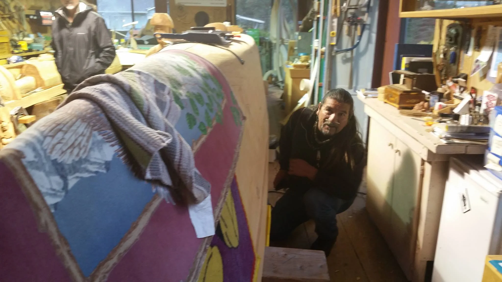 Mati Waiya looking at the under of a dug out canoe being carved.