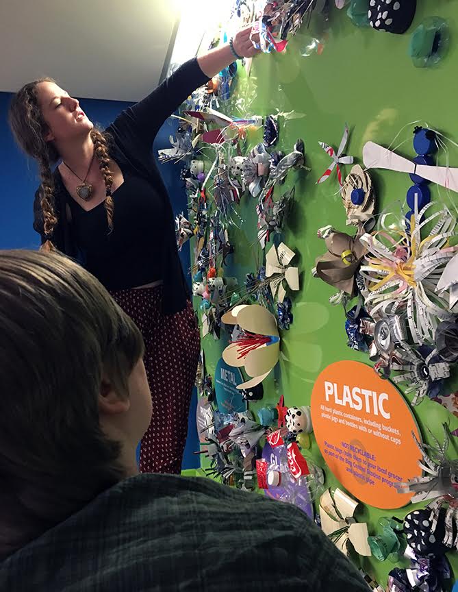 Installation was a group effort between the 3D Design Class and members of the Sustainability Club. The club also collected much of the materials used for the art objects. Pictured: foreground - Amber Ries Manning, 3D student, and Amber Bingham, Sustainability Club member