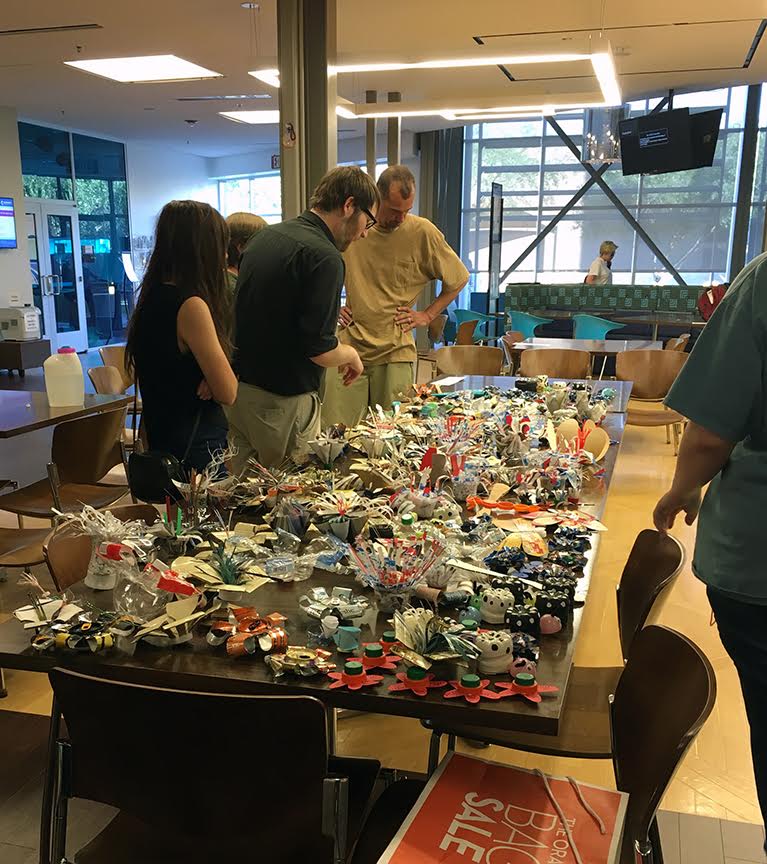 All the art objects were laid out prior to the installation. The class made over 200 flowers and bugs for the project. Pictured left to right: Nicole Nielsen, Michael McCarthy, Daniel Reed (Amber Ries Manning behind) - all 3D students