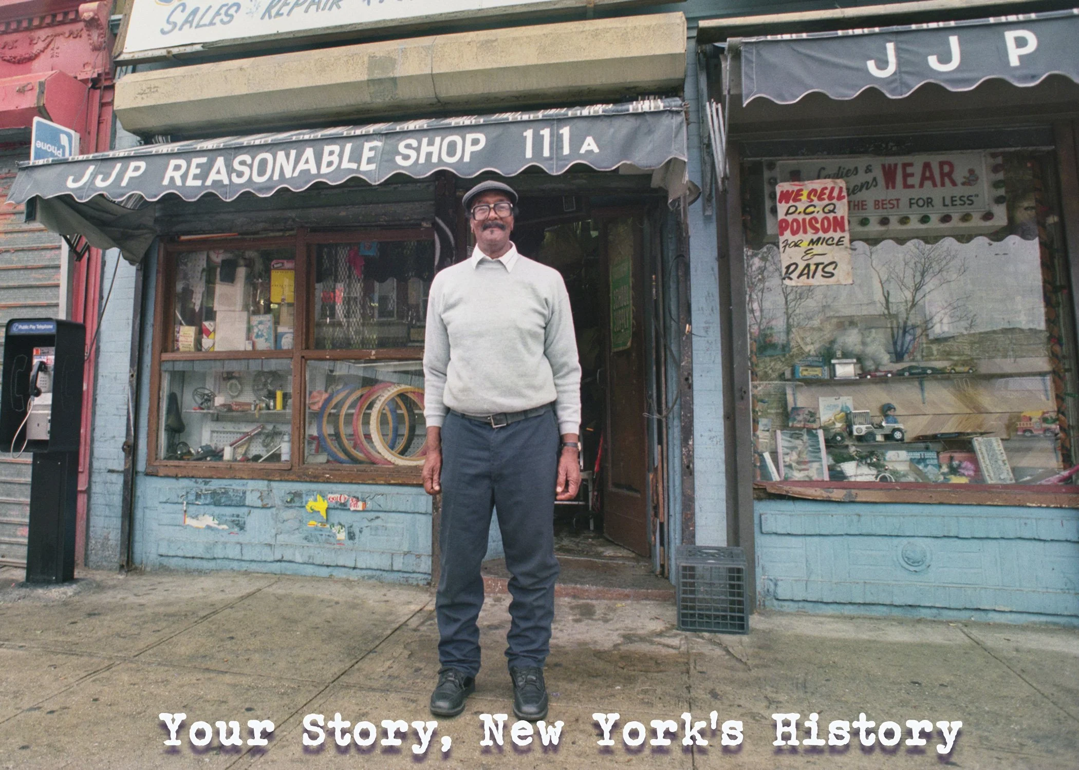 Photograph of a man smiling as he stands in front of JJP Bicycle Shop. In the foreground at the bottom of the picture, there is the text: “Your Story, New York’s History.”