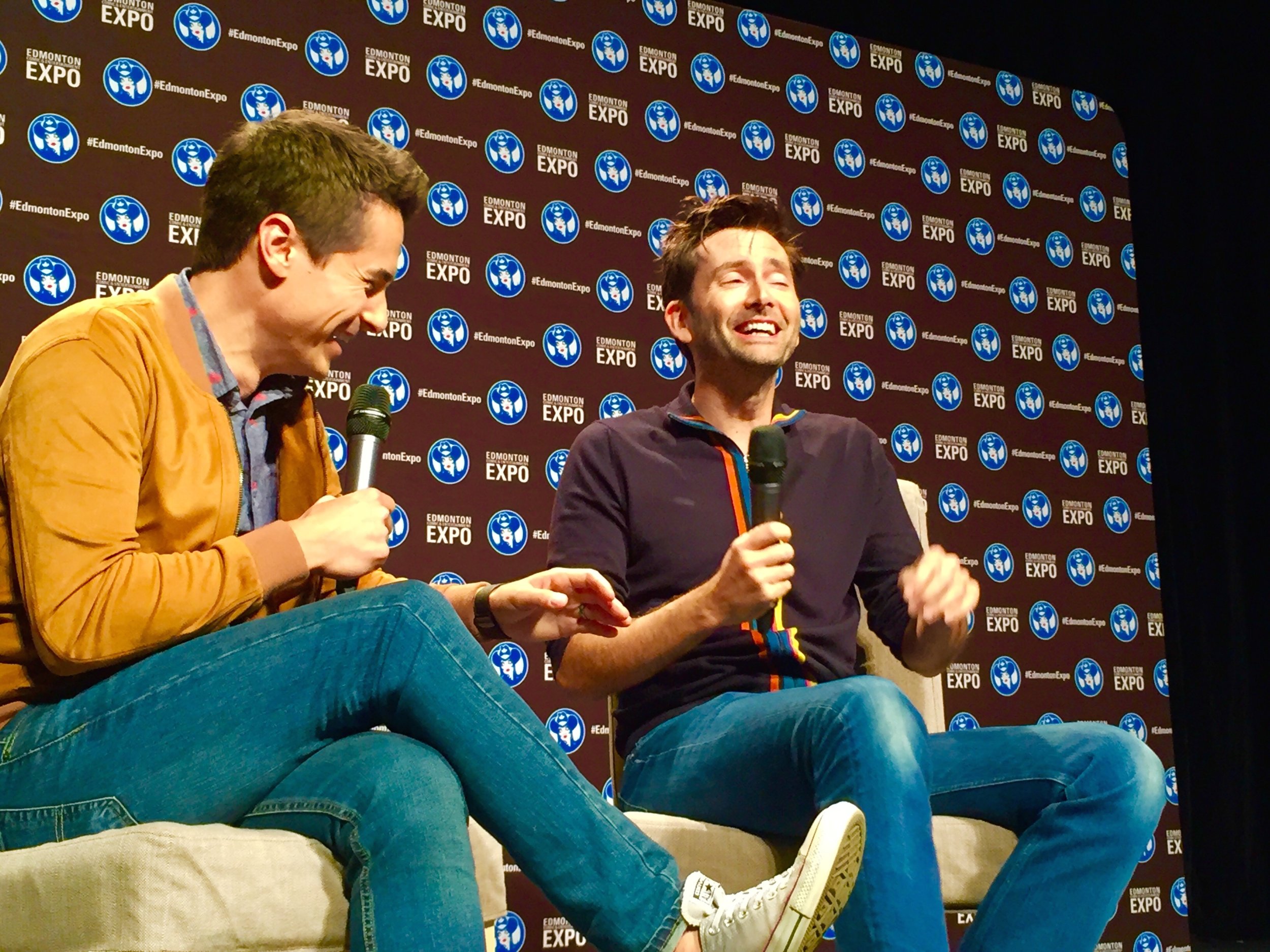 Tanner Zipchen moderating a panel with David Tennant at the 2018 Edmonton Expo. (Photo credit: Charles Cousins for GeekNerdNet.com)