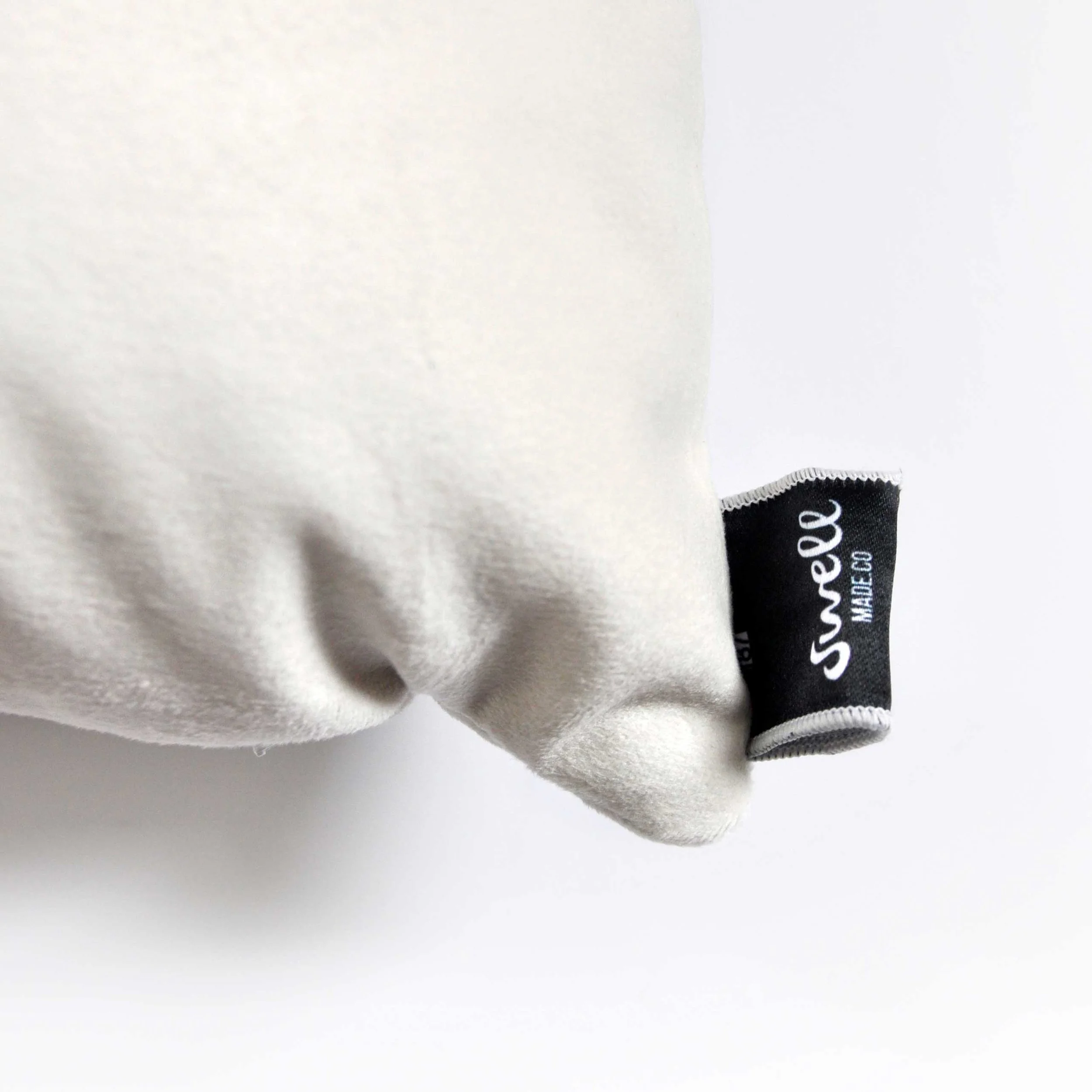 Close up of Velveteen Throw Pillow tag by Swell Made Co. Ultra soft and durable. Available as pillow cover only.