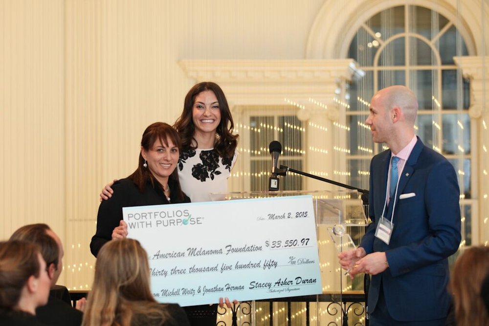 Dr. Mona Mofid receiving a donation on behalf of the American Melanoma foundation at the 2015 Portfolios with Purpose award ceremony with Stacey Asher and Jonathan Herman