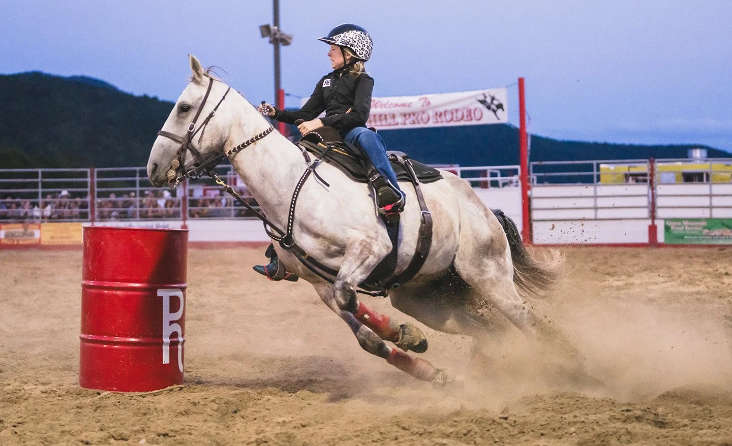 A girl races a horse around barrels at a rodeo in Vermont. Photo by Josh Trudell