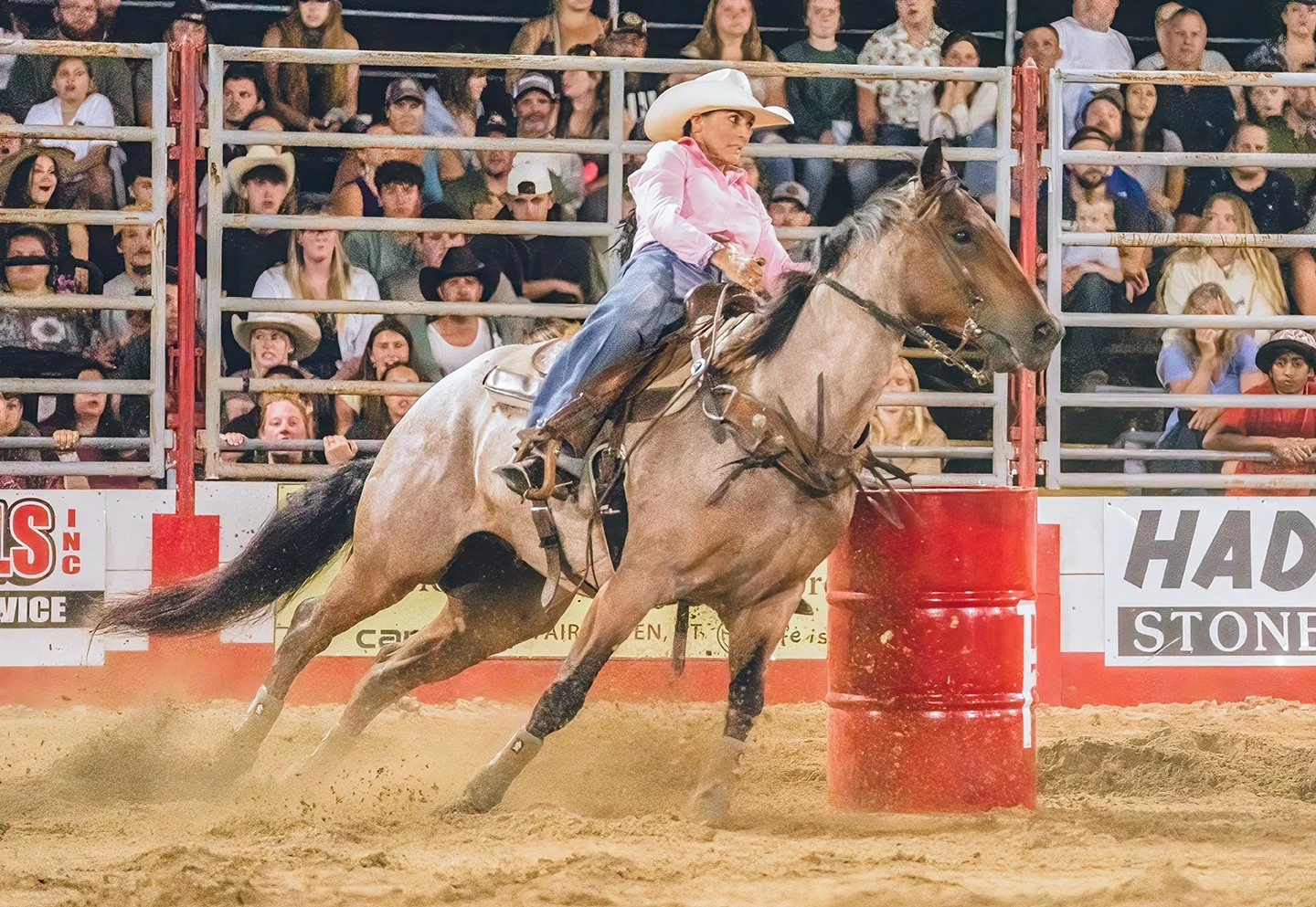 A woman races a horse around barrels at a rodeo in Vermont. Photo by Josh Trudell
