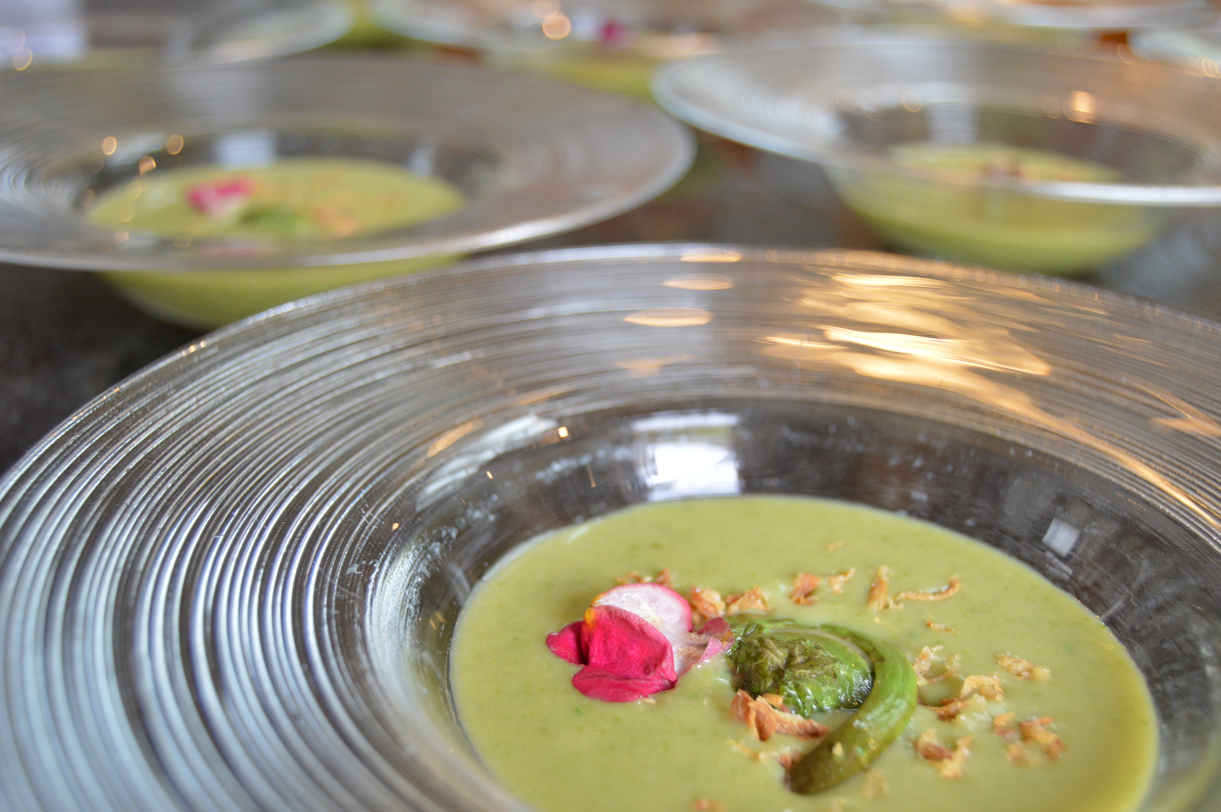 Chilled Asparagus Soup garnished with Crispy Onions, Fiddlehead Ferns, and Edible Flower Petals