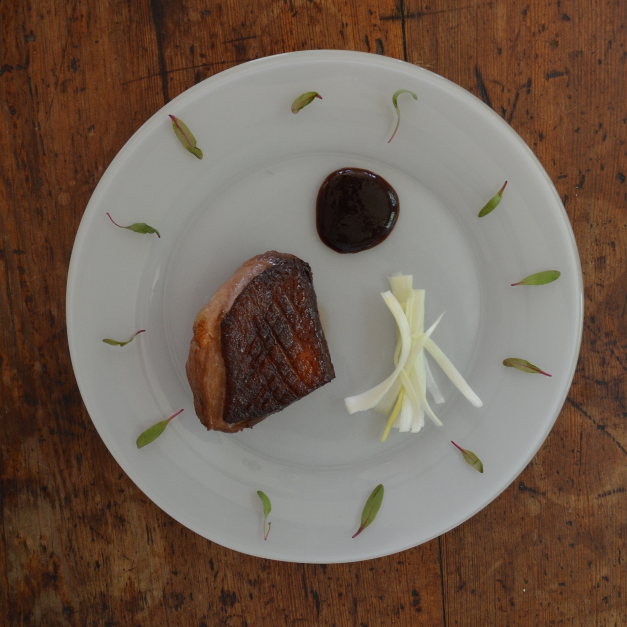 Magret de canard from D'Artagnan , Bulls Blood Beet microgreens from Good Water Farms , leeks, plum sauce