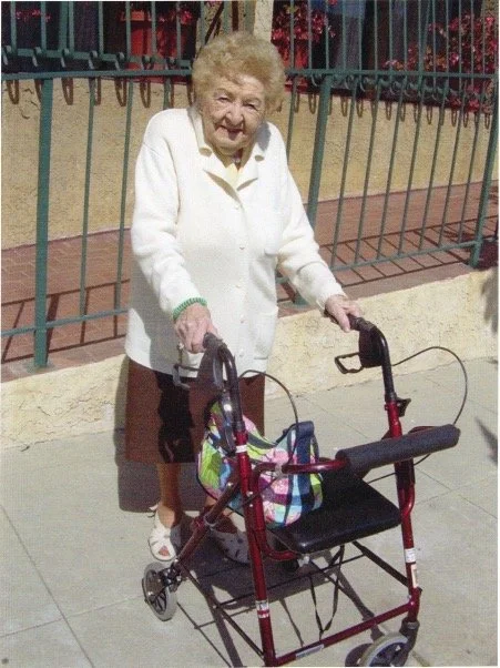Resident on walker outside home.JPG