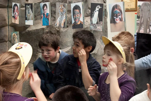                   Children using face paint at the Hamill Family Play Zoo to paint their own faces.