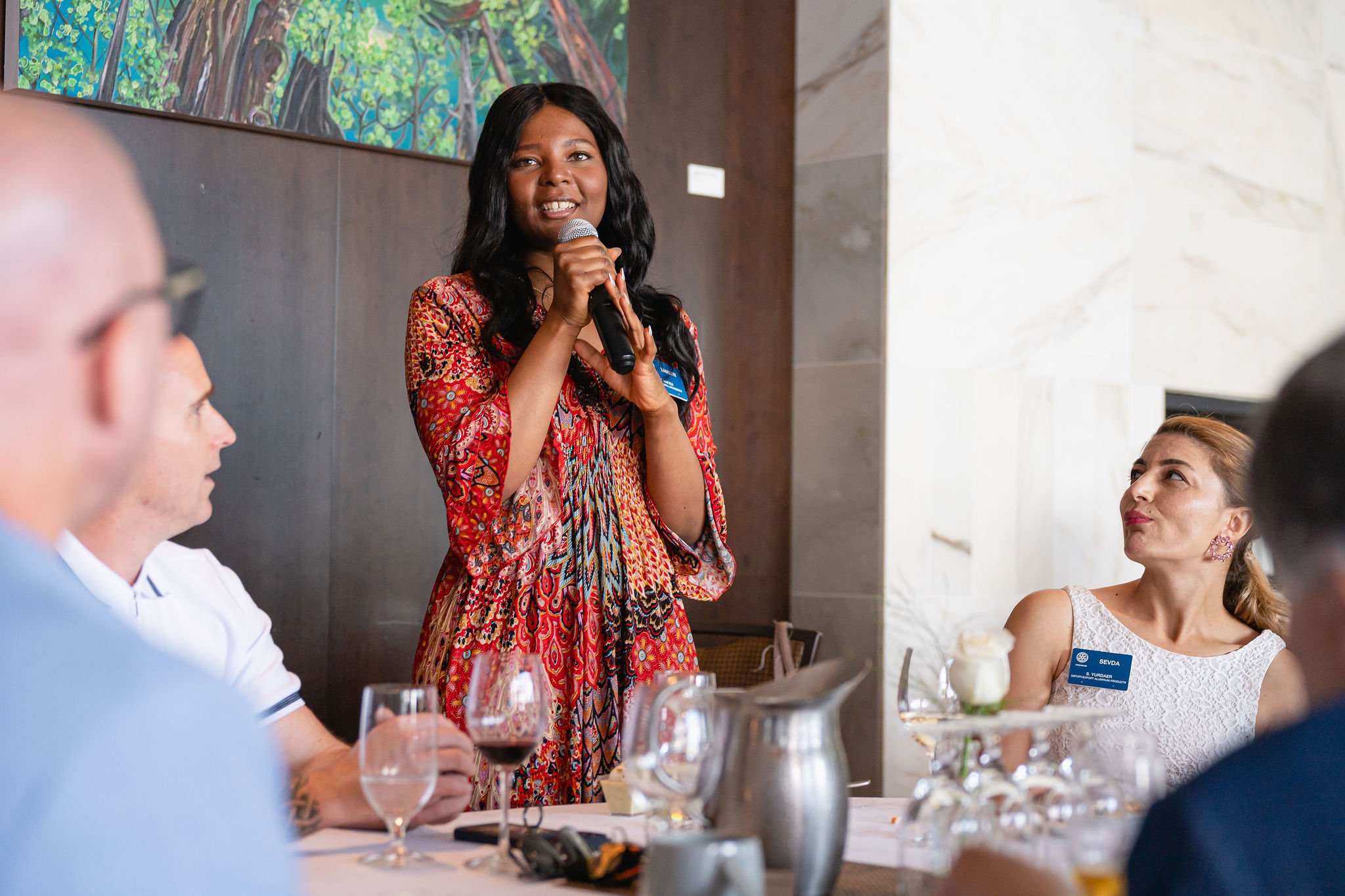 Woman speaking to guests during an intimate seated event