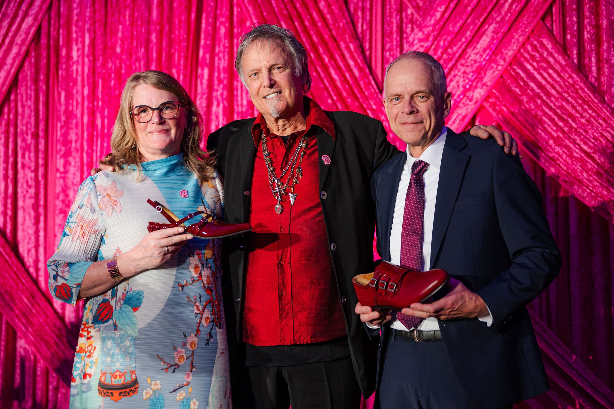 Canadian footwear designer John Fluevog posing with guests holding signature shoes