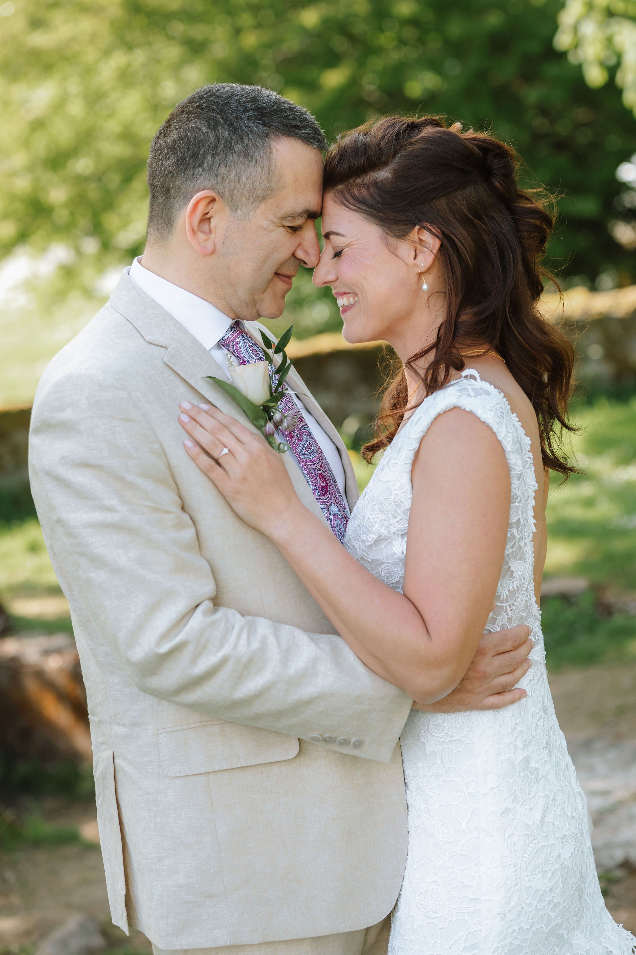 Newlyweds sharing a relaxed portrait outdoors on their wedding day.