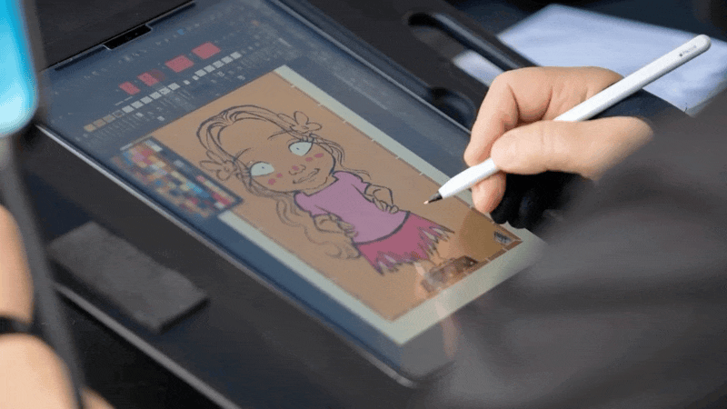 Person drawing a cartoon girl on a digital tablet with a stylus, with a layered digital art interface visible on the screen.
