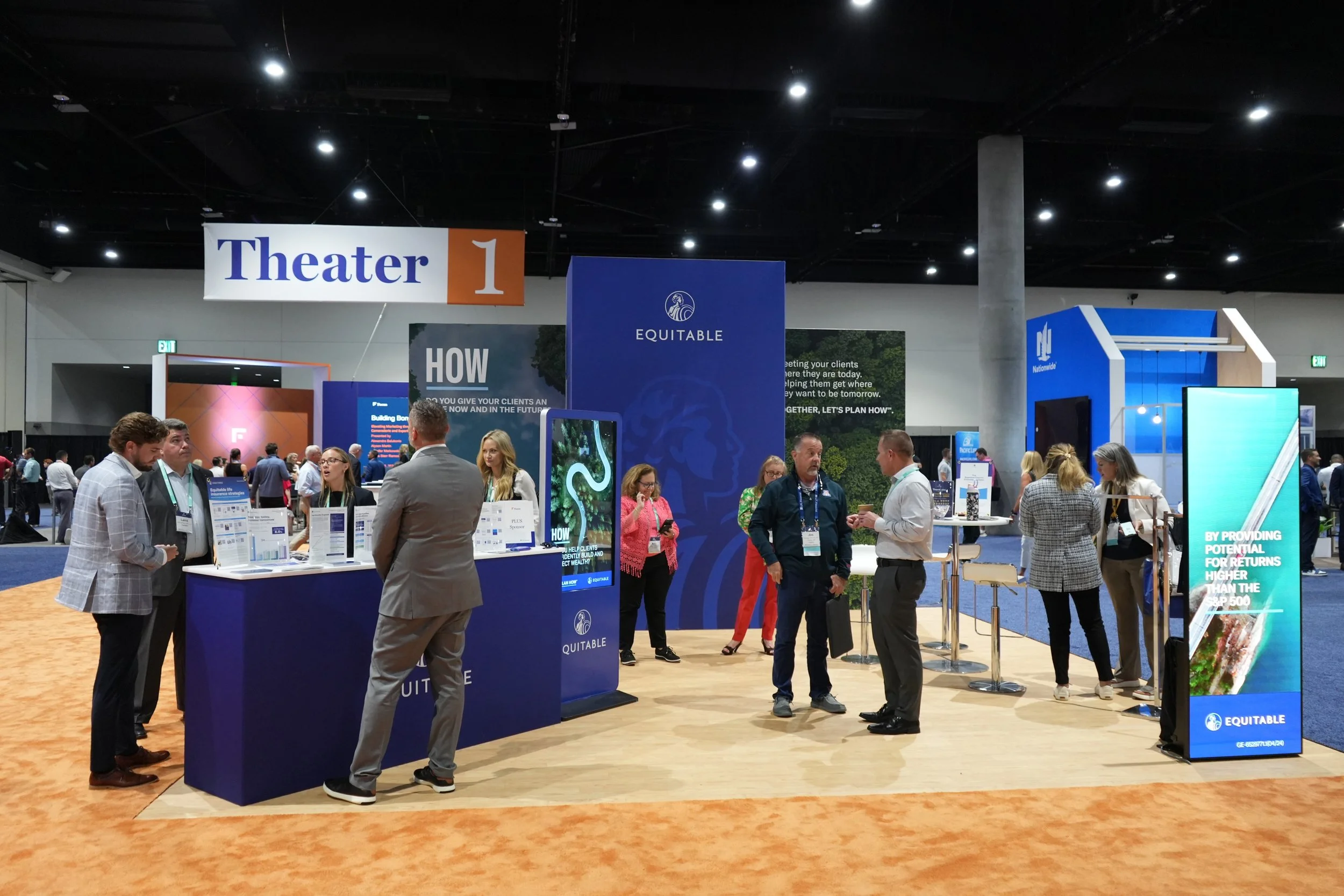 Conference exhibition hall with booths and attendees, including a booth labeled 'EQUITABLE' with people engaging at a counter and informational displays.