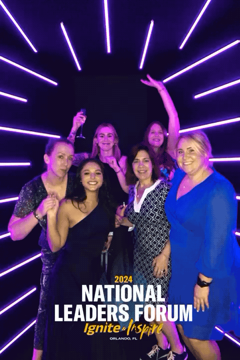 Group of women at the 2024 National Leaders Forum in Orlando, Florida, posing together with bright purple neon lights in the background.