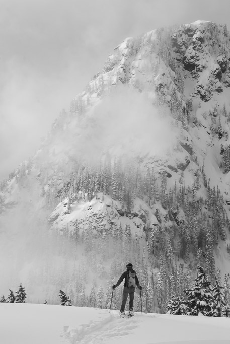 A backcountry skier surveys Guye Peak at Snoqualmie Pass, Central Cascades, Washington