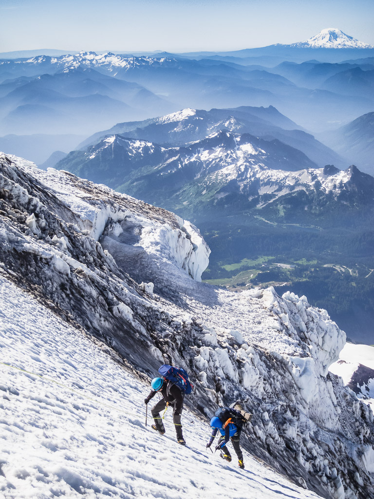 Climbers topping out on the Kautz ice chute, with Mt Adams beyond