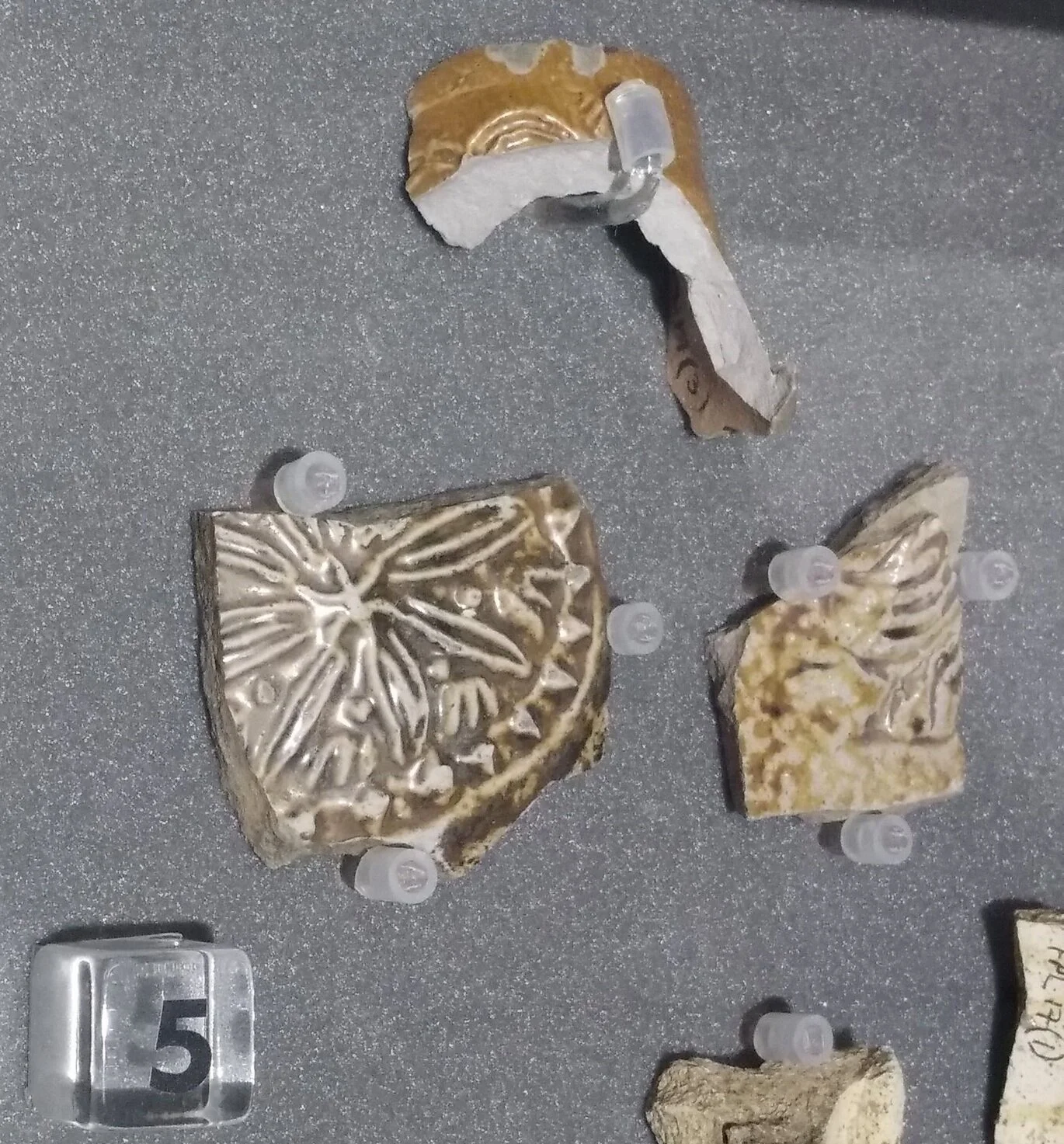Fragments of stoneware jugs produced in Frechen, near Cologne, Germany. Pottery, 1550-1700. On display at Fulham Palace in the temporary exhibition room.