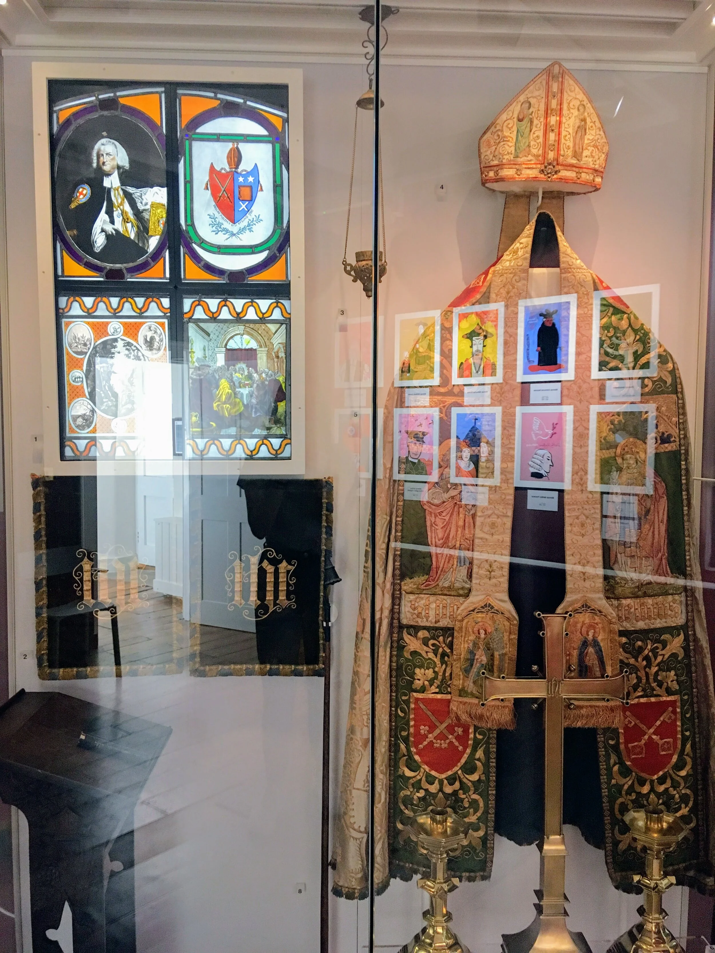 The cope on display with the mitre and crosier, alongside other objects associated with liturgical practice.