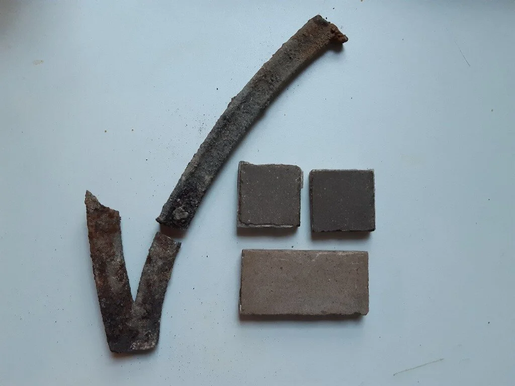 Railing fragments and original tiles from the path.