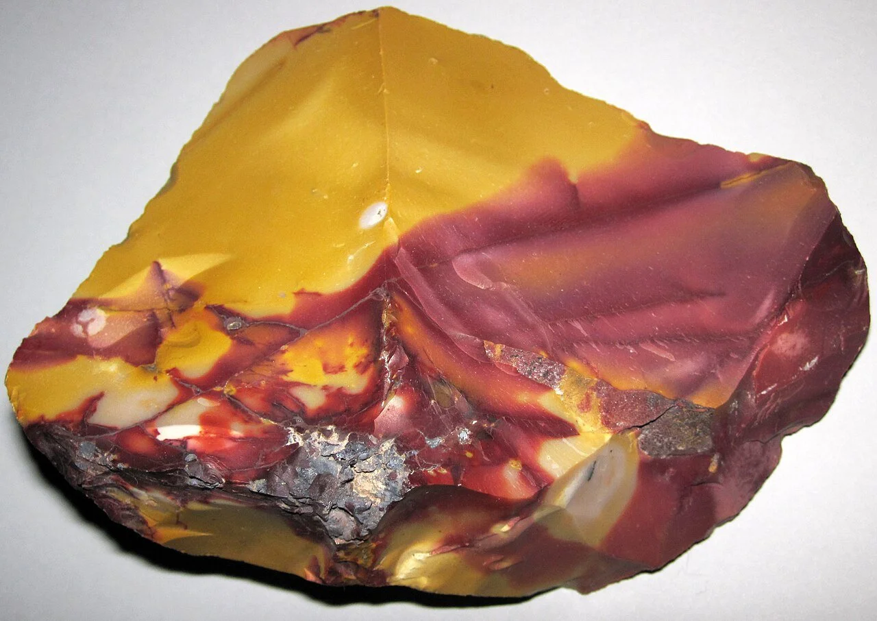 raw Mookaite showing painterly patterns in mustard yellow, burgundy, cream and brown.