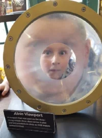 Student peers through an alvin viewport