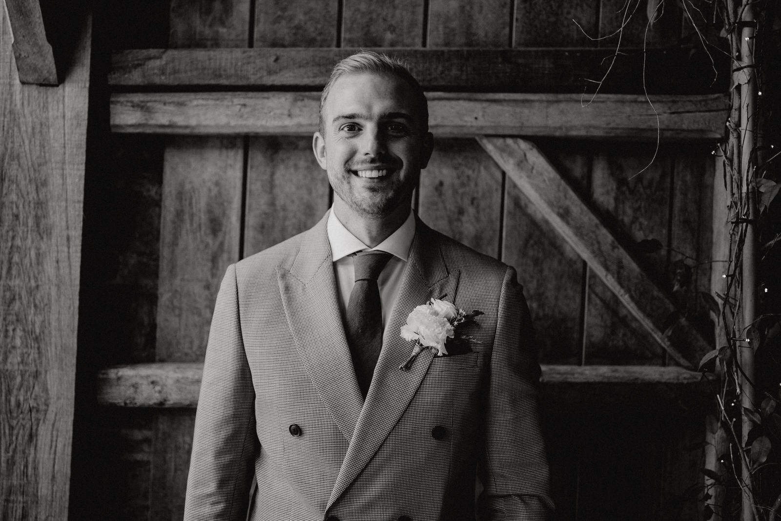 groom dressed in Reiss double breasted suit at Stone Barn Wedding