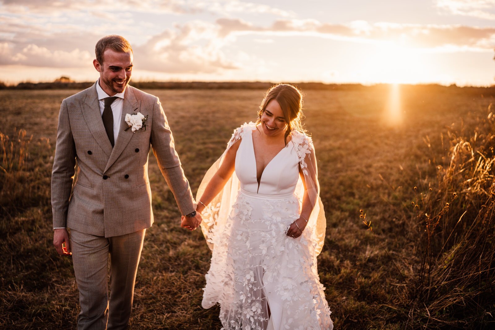 sunset shot of couple leaving field stone barn cotswolds