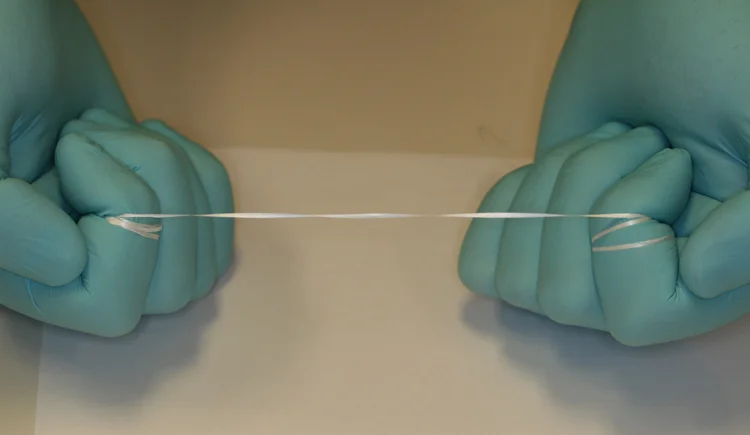 1. Pull the floss tightly between two fingers. Try either your index fingers or middle fingers.