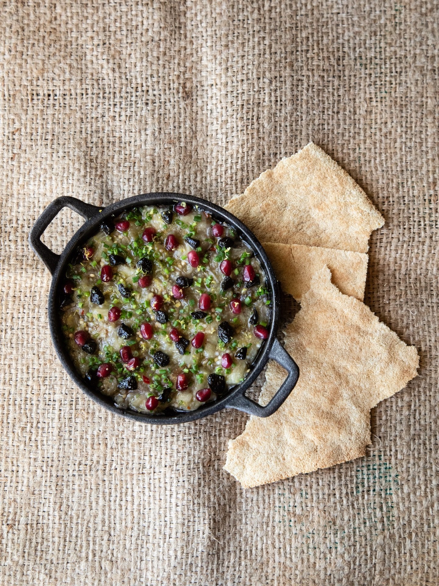 Meet Choc&aacute;,  one of our most beloved starters.

Roasted eggplant slow-cooked with fermented black garlic, aj&iacute; chirel, and olive oil. Finished with pomegranate seeds, fresh chives, and lime zest. Served in cast iron with casabe, the anci