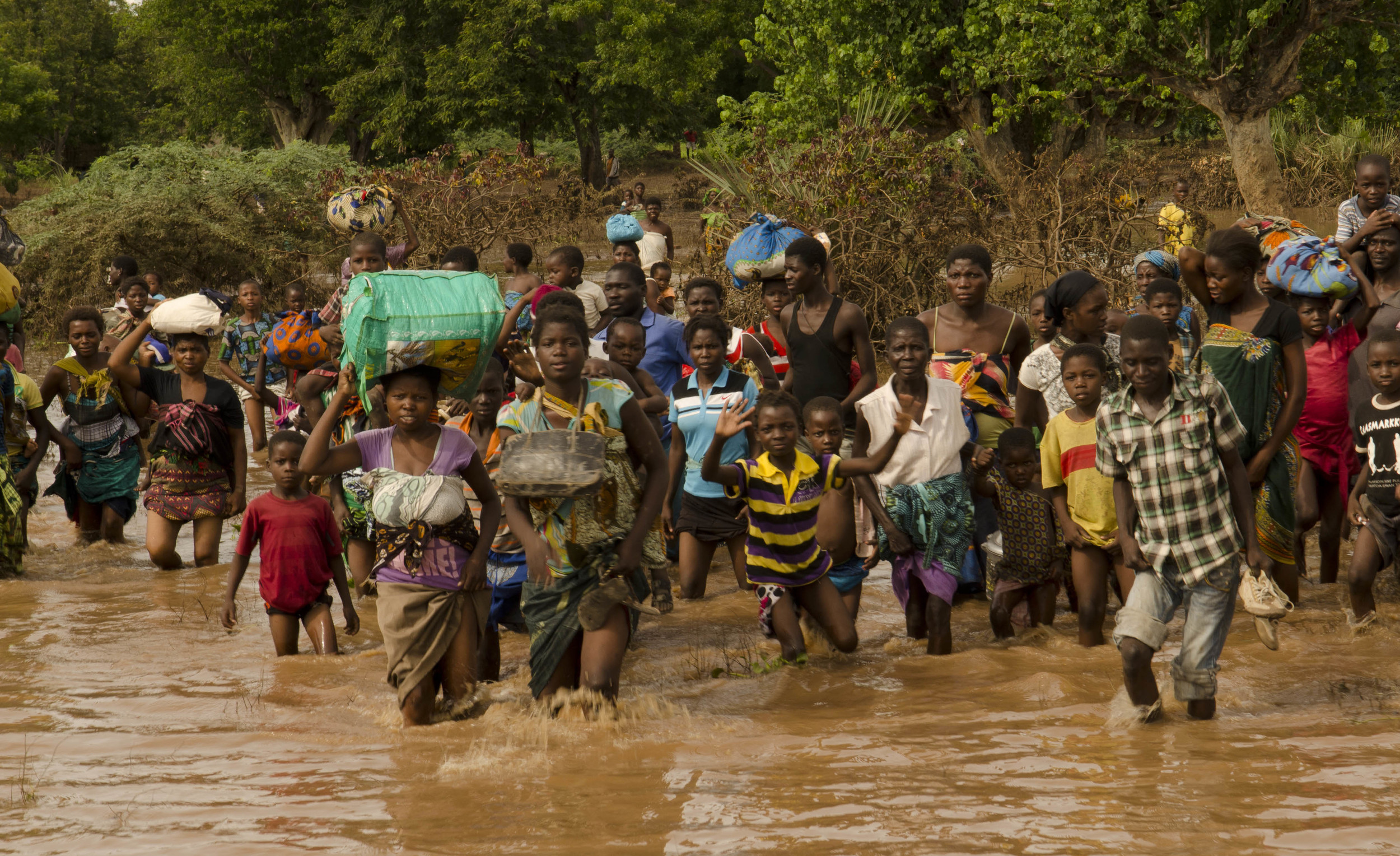 Villagers rush towards an army boat - among thousands that have been evacuated