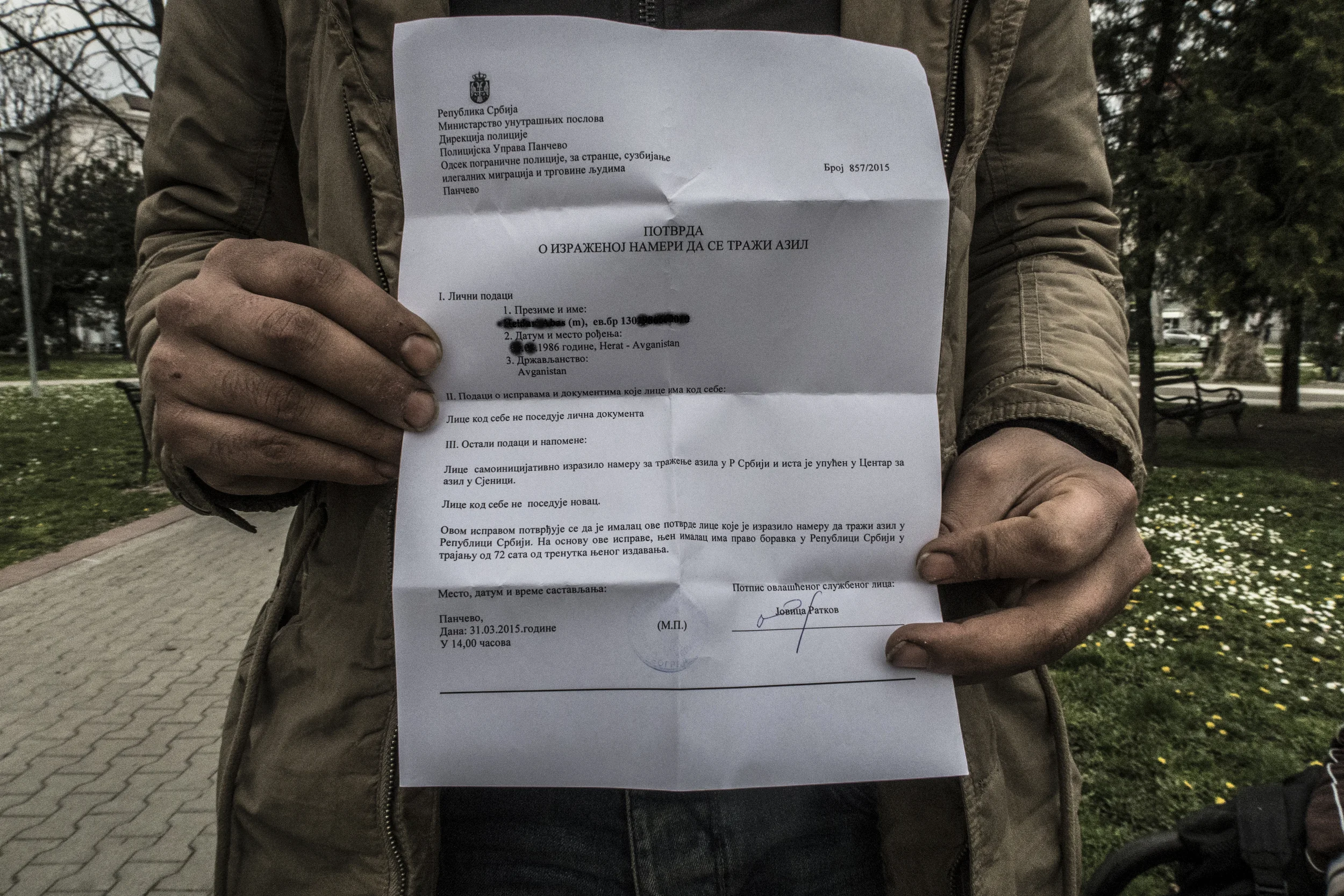 An asylum seeker holds up the registration paper issued by Serbian police that will secure him a place at a centre for asylum-seekers in Sjenica.