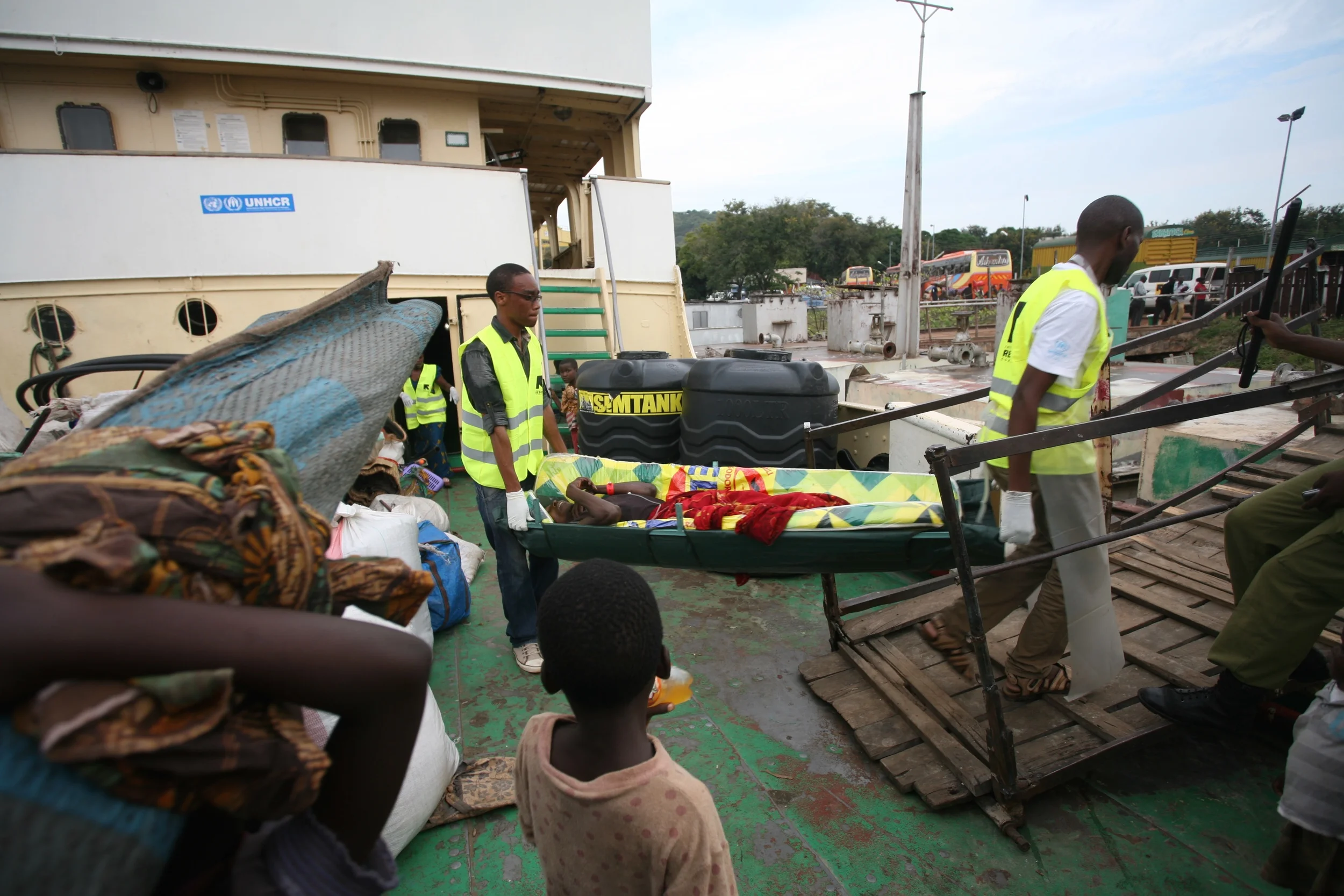 Un réfugié burundais soupçonné d’être atteint de choléra est débarqué du MV Liemba à Kigoma, en Tanzanie, par des employés du Comité international de secours.
