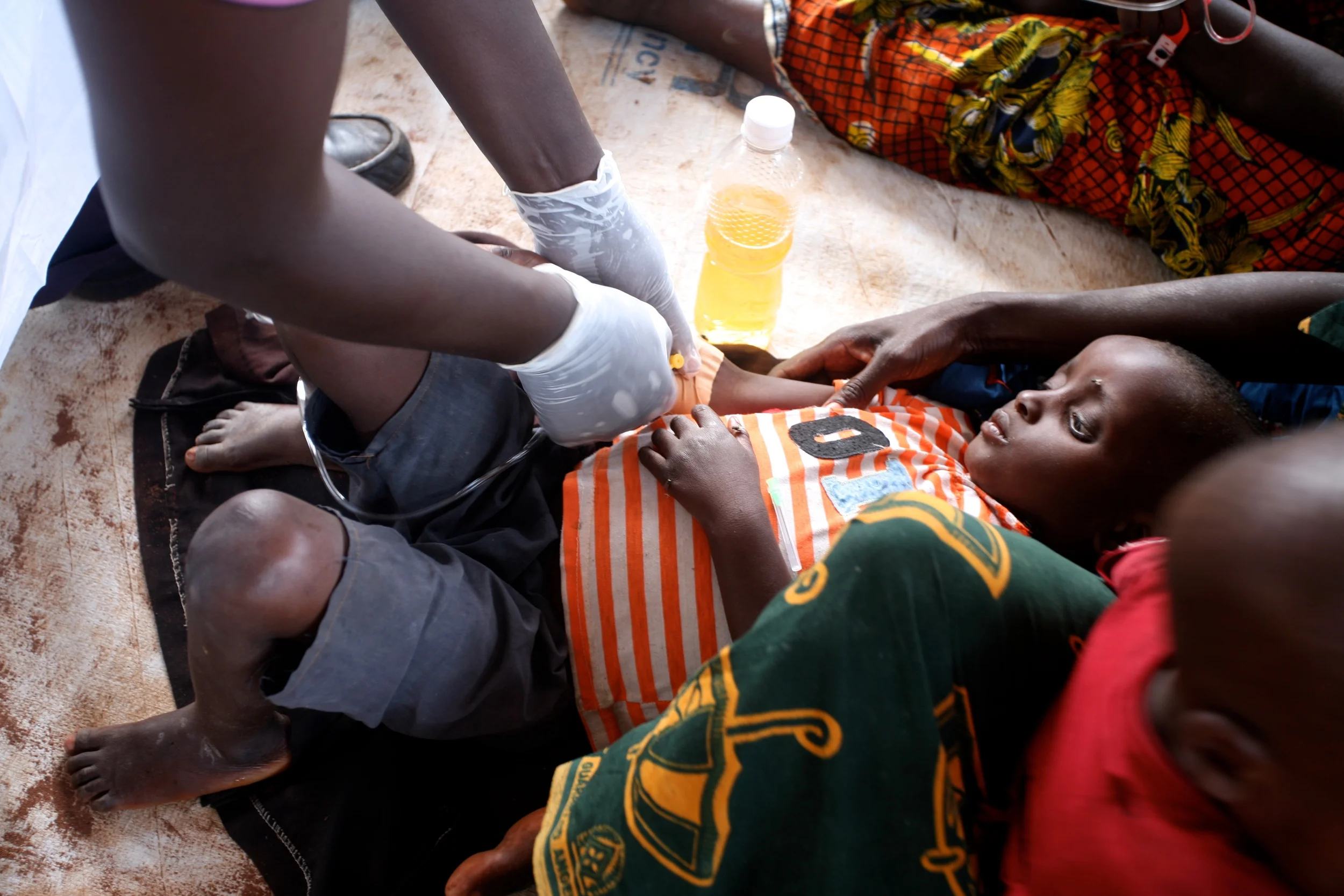 Un réfugié burundais soupçonné d’être atteint de choléra se voit administrée une solution de réhydratation par voie intraveineuse au dispensaire du stade du lac Tanganyika, à Kigoma, en Tanzanie.