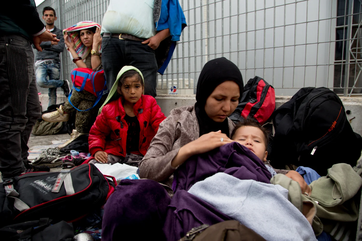 Migrants sleep rough at Mytilene's port until transport is available to take them to a detention centre