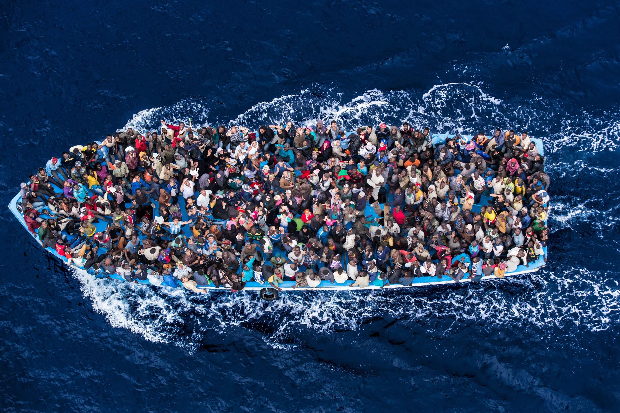 Hundreds of refugees and migrants aboard a fishing boat are pictured moments before being rescued by the Italian Navy as part of their Mare Nostrum operation in June 2014. There has been a dramatic growth in the number of refugees seeking safety by undertaking dangerous sea journeys, including on the Mediterranean (Massimo Sestini/ The Italian Coastguard )