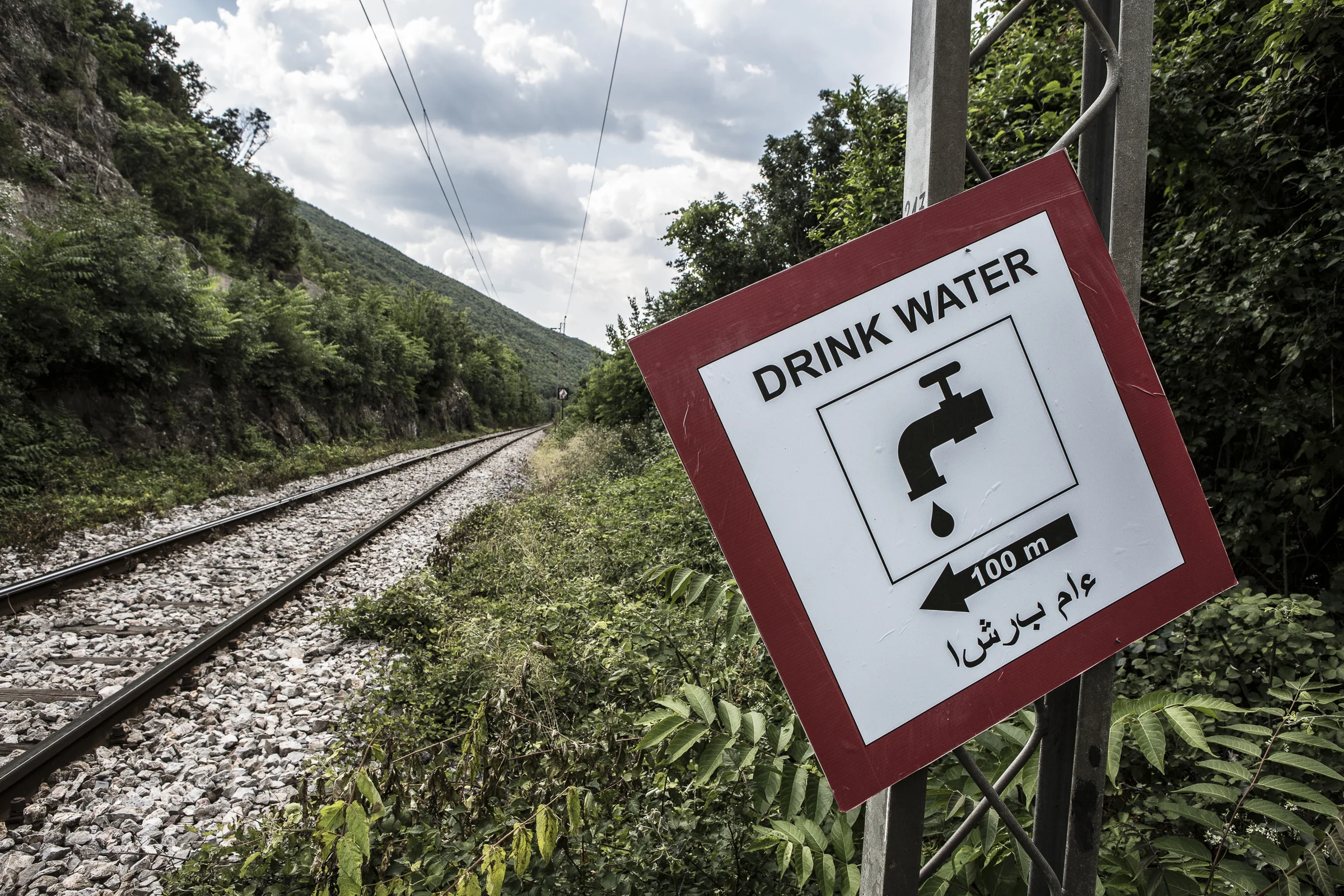One of the 60 signs that a Macedonian man has put up along the railway line warning migrants of the dangers and directing them to water fountains.