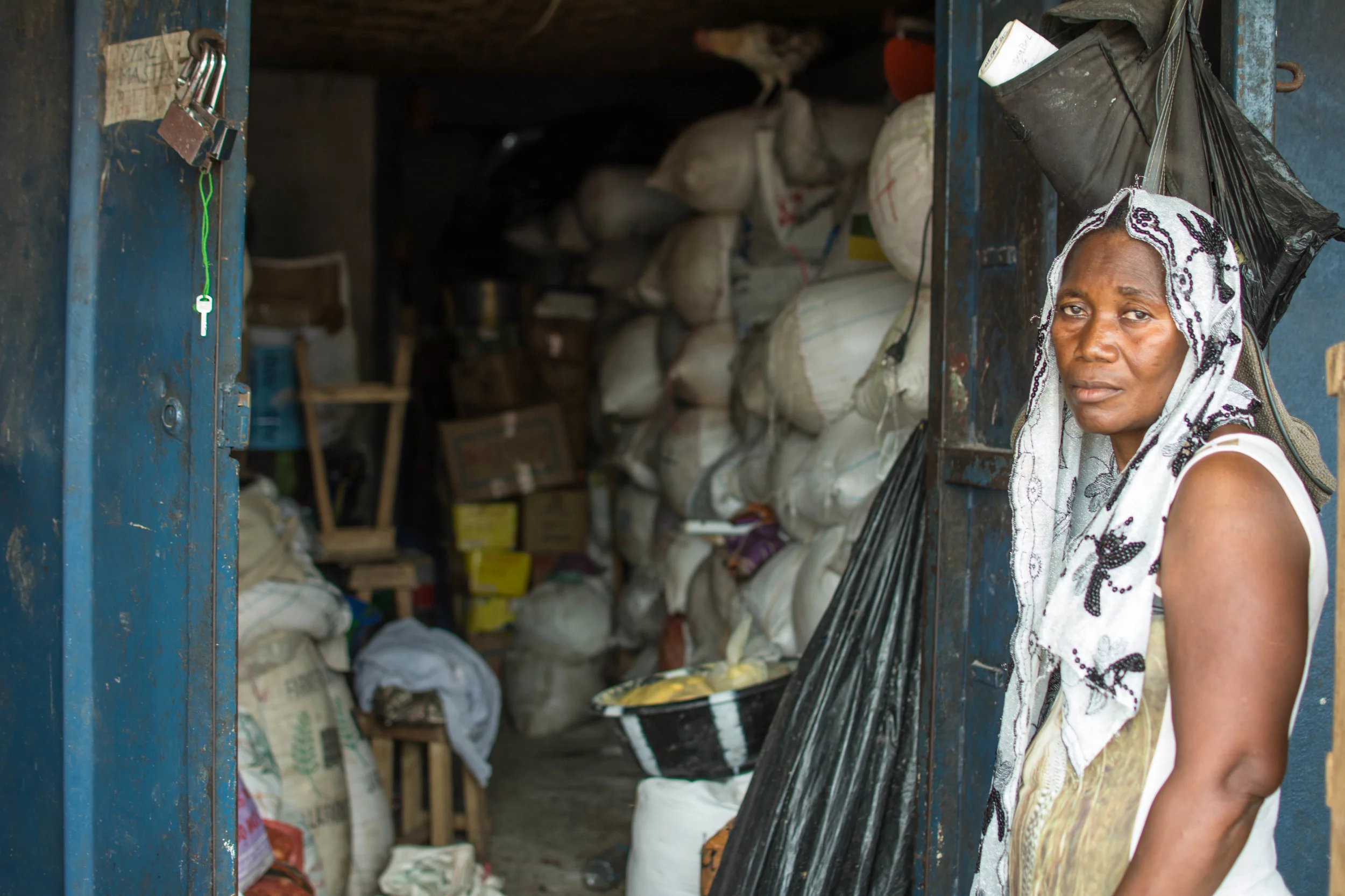 Hannah Kamanda stands outside her storehouse in Freetown, where sacks of gari have begun to pile up. Since Ebola came, she has had difficulty selling her stock. 