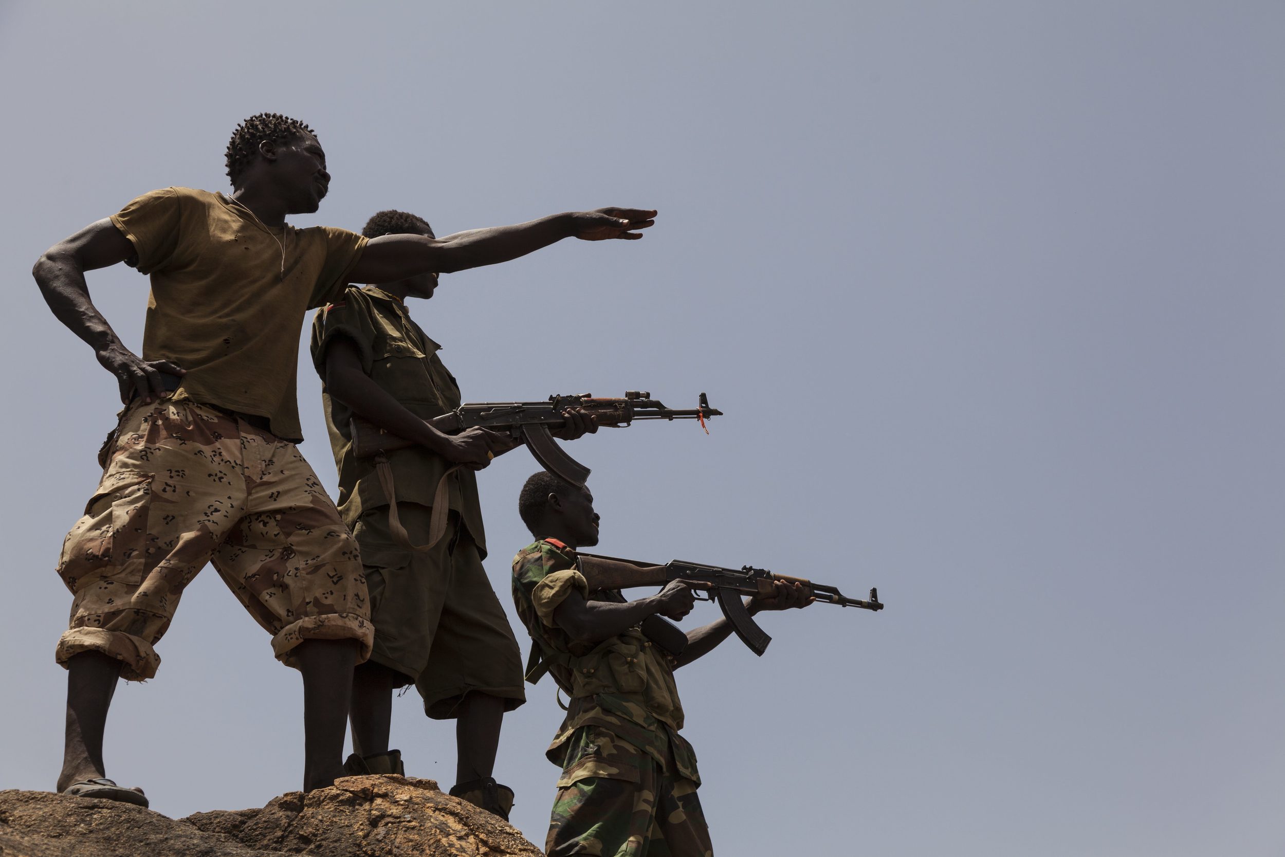 جنود من الجيش الشعبي  لتحرير السودان - قطاع الشمال يشيرون إلى قوات الحكومة السودانية من أعلى جبل في جنوب كردفان، 25 أبريل 2012