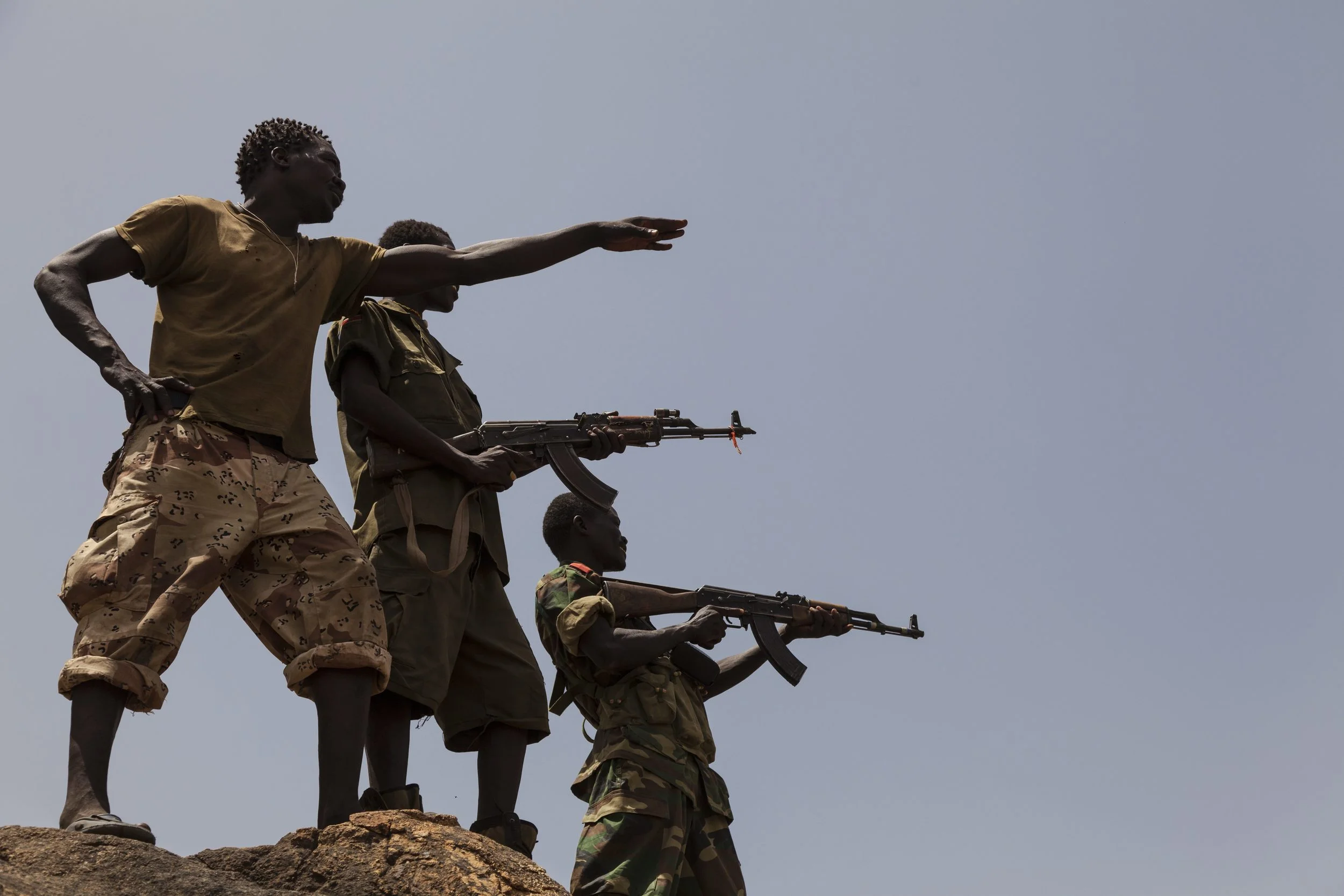 جنود من الجيش الشعبي لتحرير السودان - قطاع الشمال يشيرون إلى قوات الحكومة السودانية من أعلى جبل في جنوب كردفان، 25 أبريل 2012