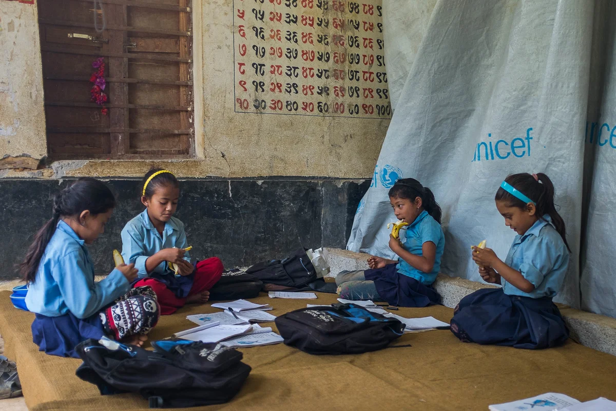 Students attend classes inside earthquake-damaged school buildings on 10 August 2015 in Sipa Pokhari. 